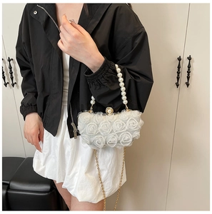 Detailed shot of white chiffon 3D floral evening bag with pearl handle and gold chain strap