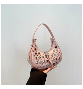 Detailed macro of pink crescent bag with silver stud accents and metallic zipper