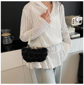 Detail of 3D rose textured evening bag with large pearl handle and gold chain strap