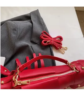 Detail view of red fashion bag with smooth long shoulder strap and gold hardware