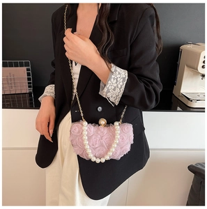 Detail of pink floral mesh evening bag with pearl handle and golden chain shoulder strap
