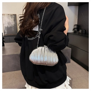 Silver shell-shaped clutch with pleated metallic finish and slim chain strap