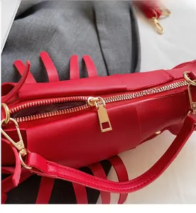 Close-up of smooth gold zipper and red lychee leather texture on lobster shaped bag
