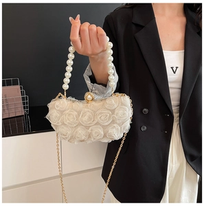 Detail of elegant white 3D mesh rose handbag with pearl handle and gold chain strap
