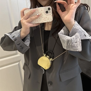 Mini gold mirror acrylic box bag with black handle and chain shown on a fashion model