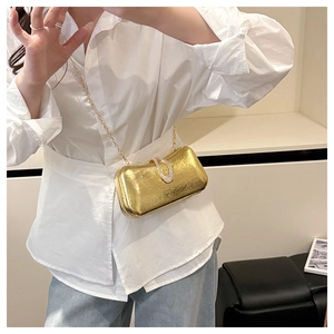 Detail of gold evening bag with metallic texture, crystal buckle and chain strap