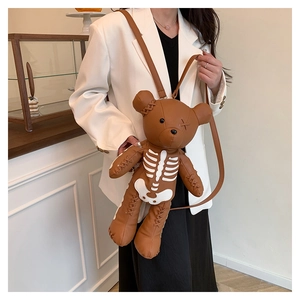 Detail of brown leather bear bag featuring white bone print and artisanal stitching