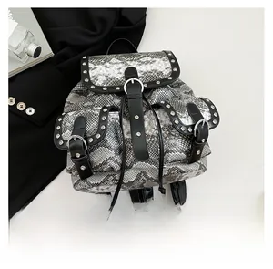 Macro detail of snakeskin texture backpack with silver rivets and metallic buckle straps
