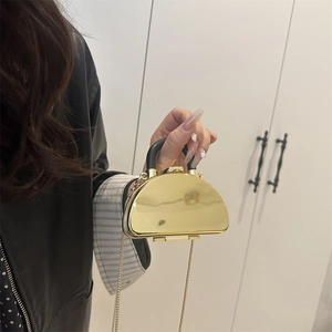 Glossy gold semi-circle mini lipstick bag with black handle and gold chain strap