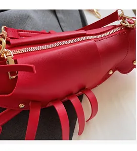 Close-up of red lobster-shaped handbag with rivet details and soft leather texture