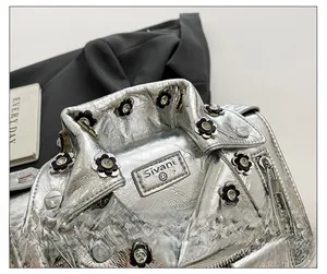 Detail of silver biker jacket bag with studded floral hardware and metallic texture