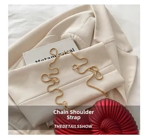 Detailed view of red acrylic shell bag with spiral texture and gold chain strap
