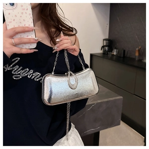 Close-up of silver evening bag with metallic texture and rhinestone encrusted U-shaped lock