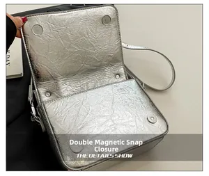 Detail view of the metallic silver crossbody bag featuring a secure double magnetic closure