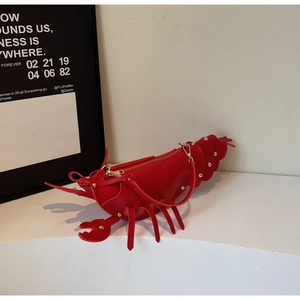 Detail of creative red lobster shoulder bag with golden rivets and metallic zipper