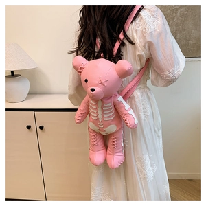 Pink bear backpack with skeleton print worn by model in white lace dress