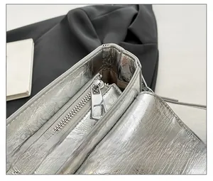 Detail of silver metallic leather texture and smooth zipper on the punk style bag