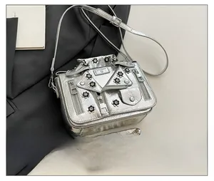Macro detail of silver motorcycle jacket bag with metal zippers and 3D floral accents