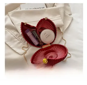 Detailed interior view of red shell-shaped evening clutch bag with gold rose clasp