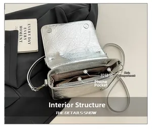 Interior layout of silver crossbody bag with main pocket, zipper pocket and phone slot