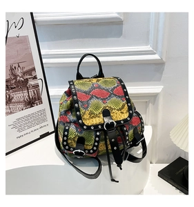 Close-up of vibrant snakeskin pattern backpack with silver studs on a white pedestal