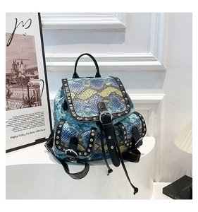 Detail view of snakeskin pattern and silver rivets on a vintage fashion backpack