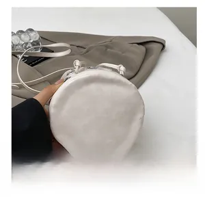 Close-up of durable circular base on white leather bucket bag with silver metal rivets