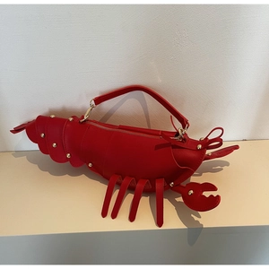Detailed view of red lobster bag with golden rivets and realistic crustacean shape design