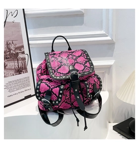 Detail of snake print backpack with silver rivets on a white display stand