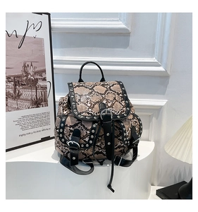 Detail of snake print backpack with black leather straps and silver metal rivet accents