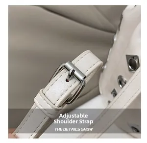Detail view of adjustable beige leather shoulder strap with polished silver metal buckle