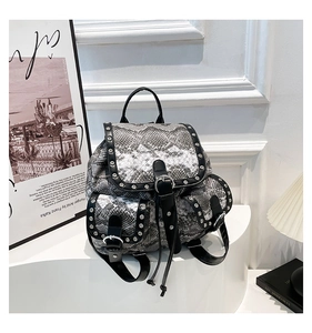 Close-up of vintage snake print backpack featuring silver rivets and metal buckle details