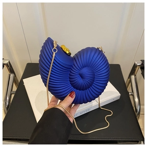 Close-up of royal blue shell-shaped clutch with gold chain and spiral texture
