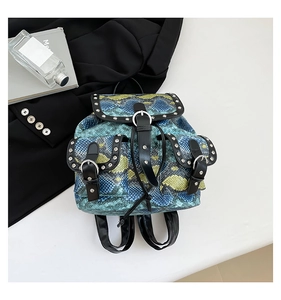 Top view of faux snakeskin mini backpack featuring silver studs and metal ring accents