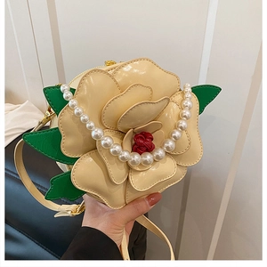 Detailed view of cream camellia-shaped bag with pearl chain and leather shoulder strap