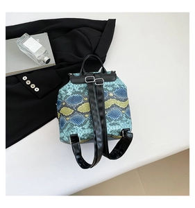 Top view of a mini snakeskin backpack featuring blue and yellow textures with silver buckles