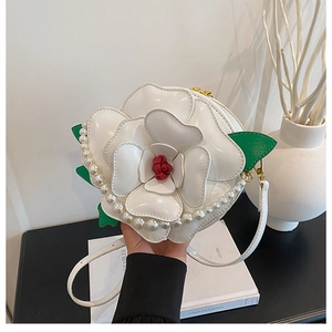Detail of floral crossbody bag featuring 3D camellia petals and elegant pearl trim
