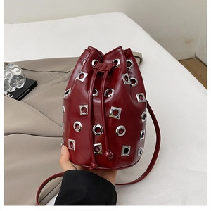 Détail du sac seau bordeaux avec rivets métalliques et fermeture à cordon de serrage