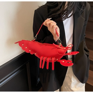 Detailed view of the lobster-shaped handbag with golden studs and vegan leather texture