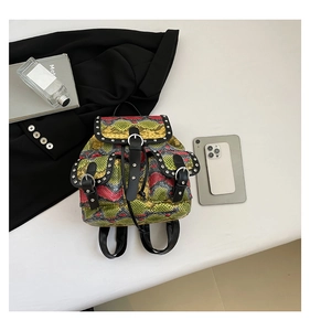 Detail of colorful snakeskin texture and silver studs on a punk style mini backpack