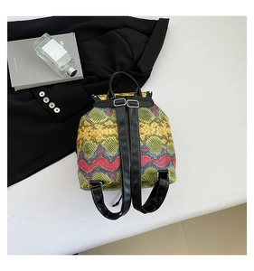 Detail of vibrant snakeskin pattern on stylish backpack with silver metal buckles