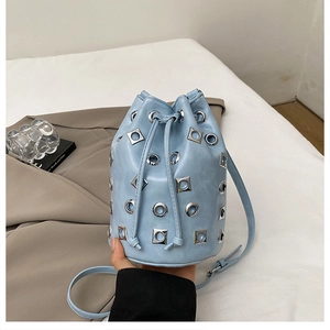 Détail du sac seau bleu clair avec œillets métalliques argentés et cordon de serrage