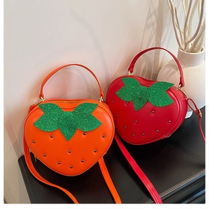 Détail de sacs fraise rouges et orange avec rivets métalliques et feuilles à paillettes