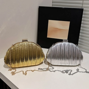Elegant gold and silver pleated metallic chain shell bags with minimalist indoor setting
