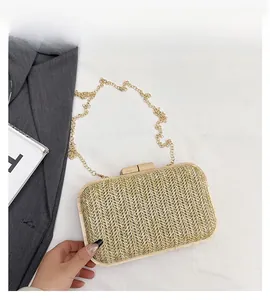 Detail of woven straw evening bag with wooden frame and elegant gold chain strap