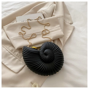 Detailed close-up of a black seashell acrylic box bag with gold metal chain