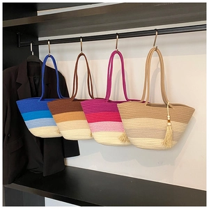 Detail of four colorful woven tote bags with gradient patterns and tassel accents
