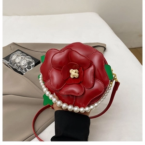 Detail of red camellia flower round bag with pearl handle and leather shoulder strap