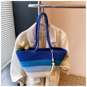 Detail of blue gradient woven tote bag with fringe tassel and long top handles