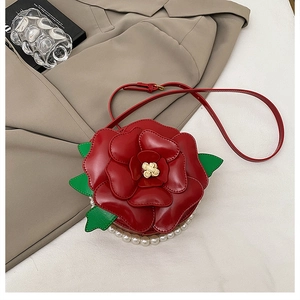 Detail of red rose shoulder bag with petal layers, green leaves and pearl trim decor